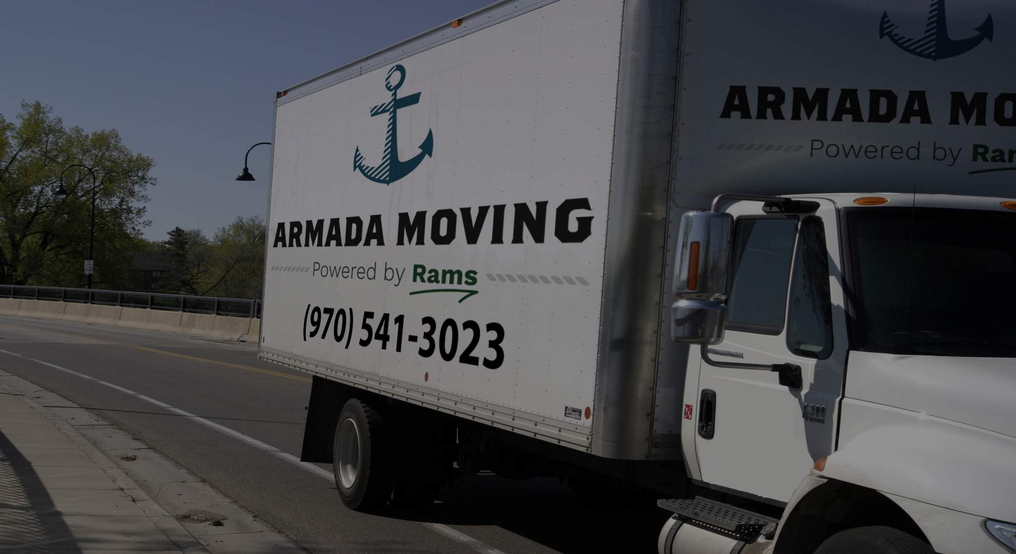 An Armada Moving box truck — anchor logo and (970) 541-3023 on the side — parked on a Fort Collins street